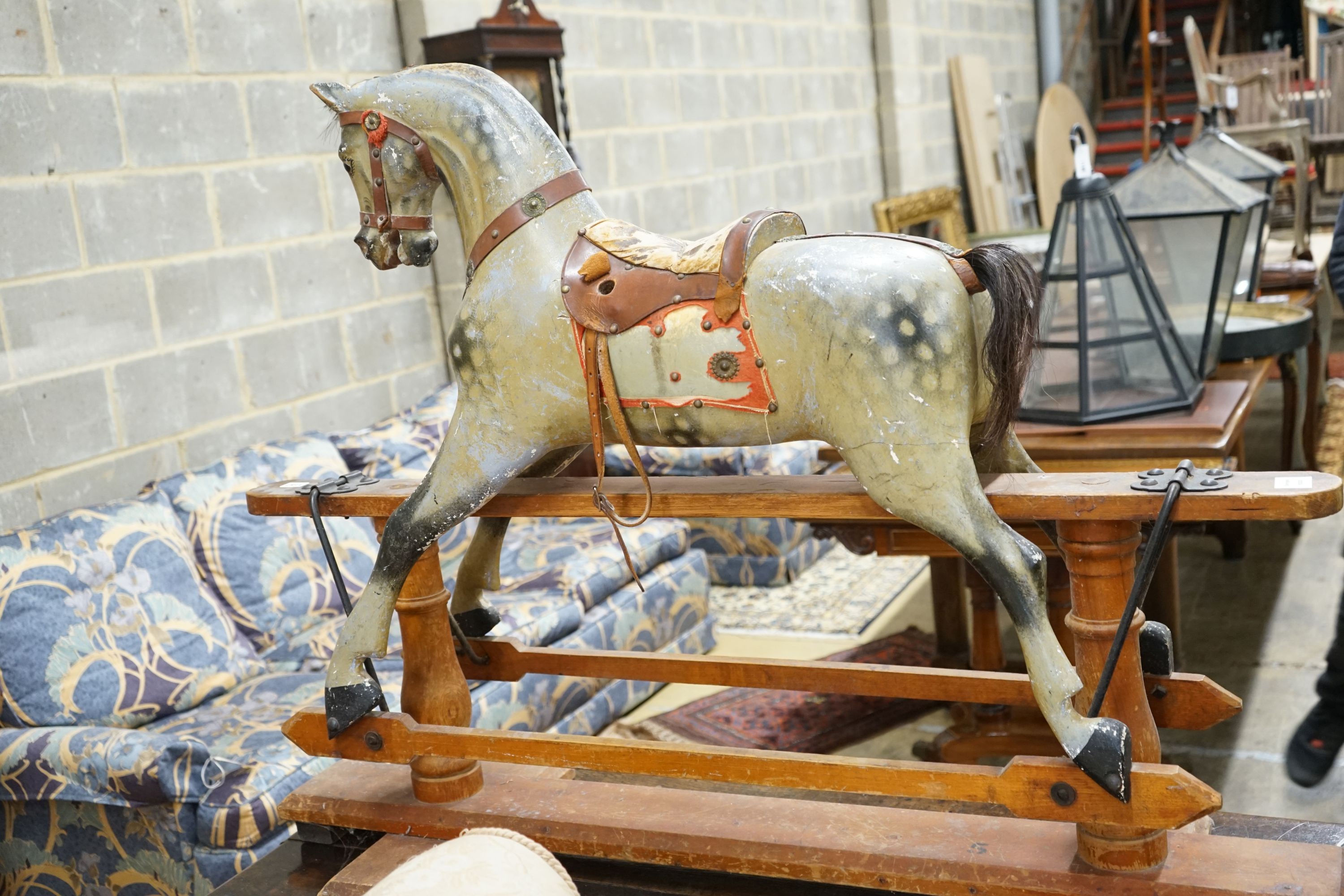 An Edwardian carved wood and dapple painted rocking horse, raised in a trestle frame, length 127cm, height 95cm